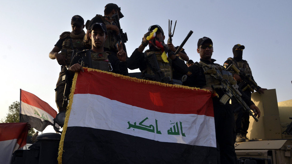 Soldados iraquíes sostienen la bandera nacional en Mosul tras anunciarse el fin de la guerra. EFE