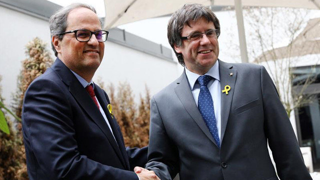 O recentemente elixido presidente da Generalitat de Cataluña, Quim Torra, estreita a man ao seu predecesor, o expresidente catalán Carles Puigdemont, durante unha rolda de prensa este martes en Berlín. OMER MESSINGER (EFE)