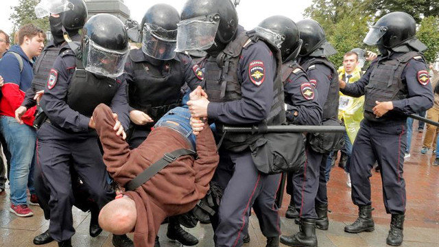 La policía antidisturbios rusa lleva a un participante detenido. MAXIM SHIPENKOV (EFE)