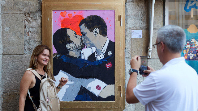 El artista urbano TVBoy pintó en Barcelona a Pedro Sánchez y Pablo Iglesias fundiéndose en un beso. A.GARCÍA (EFE)
