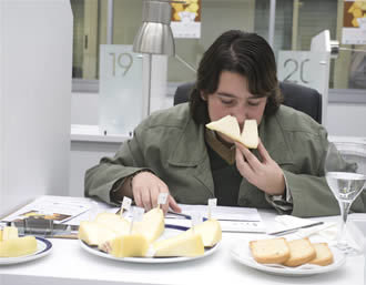 Una técnica evalúa un pedazo de queso gallego en una cata (AGN)