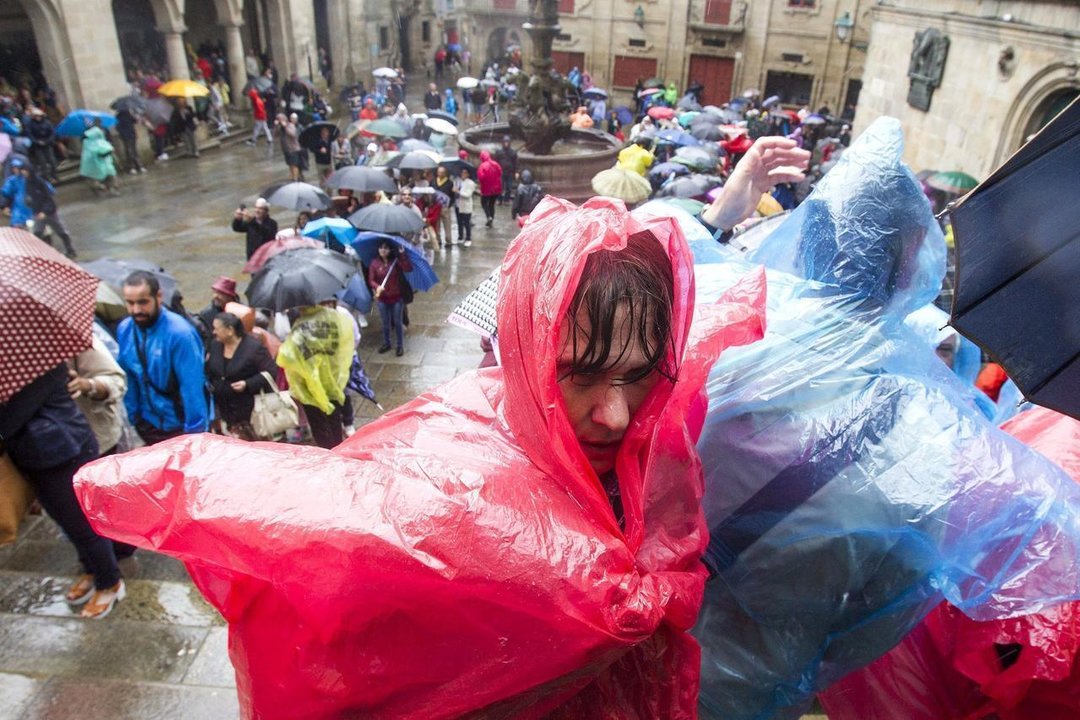 Dos turistas se protegen de la lluvia con chubasqueros desechables
