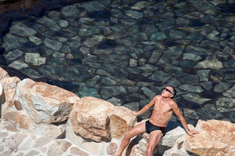 Un hombre toma en sol en una zona fluvial del río Miño en Ourense