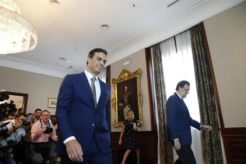 El presidente del PP, Mariano Rajoy, y el secretario general del PSOE, Pedro Sánchez, caminan separados