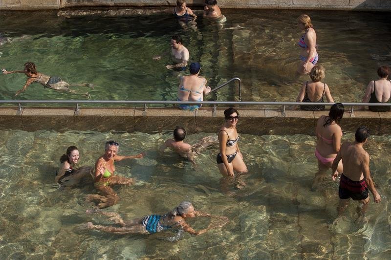 Varias personas combaten el calor en la piscina termal de As Burgas, en Ourense