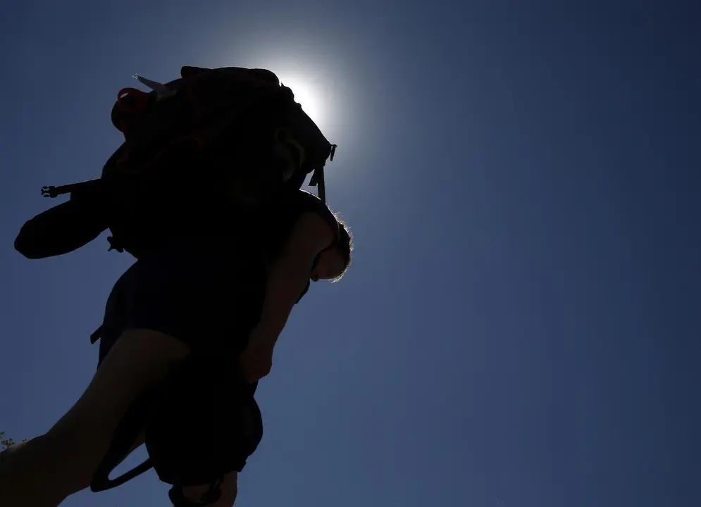 Una peregrina camina bajo el sol