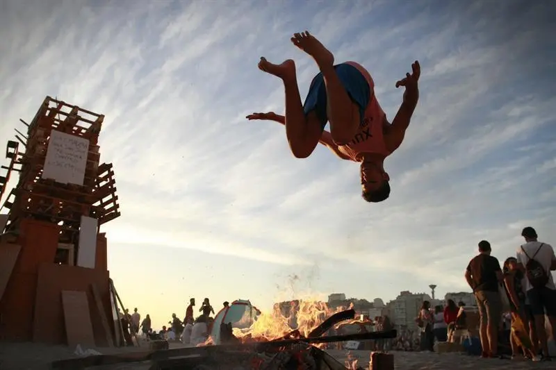 Un joven salta una hoguera en una playa de A Coruña