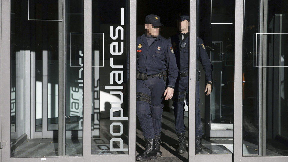 Dos agentes de policía salen de la sede del PP, en la madrileña calle Génova