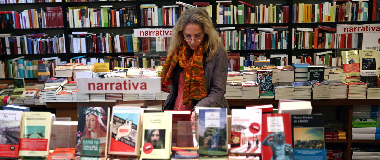 Una mujer consulta varios ejemplares en una librería. AEP