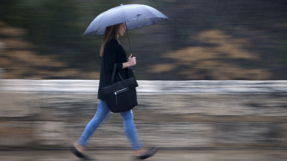 Una joven se protege de la lluvia bajo un paraguas