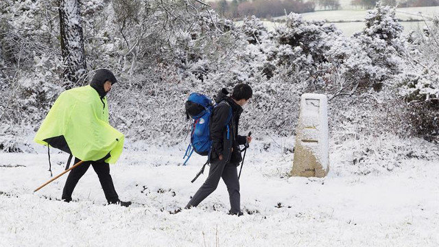 Peregrinos caminante entre la nieve en la montaña de Lugo. ELISEO TRIGO (EFE)
