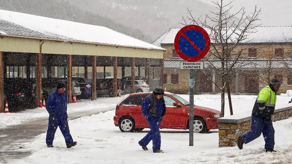 Uns traballadores camiñan por unha rúa de Pedrafita. ELISEO TRIGO (EFE)