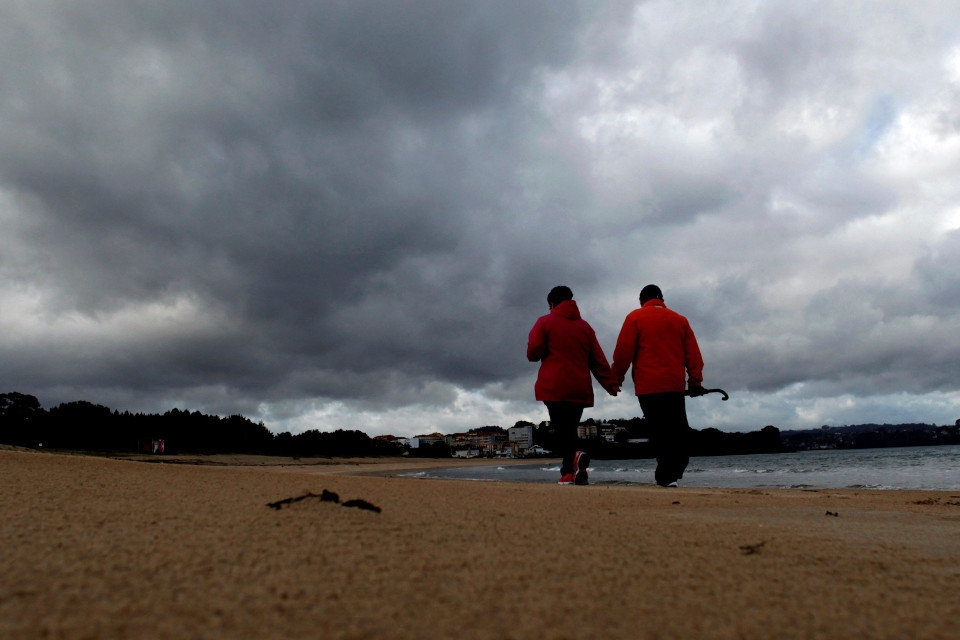 Una pareja pasea por la playa en Miño