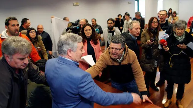 Vista dun momento de tensión durante a moción de censura, na que os veciños intentan expulsar a representantes políticos do salón de plenos. ELISEO TRIGO (EFE)