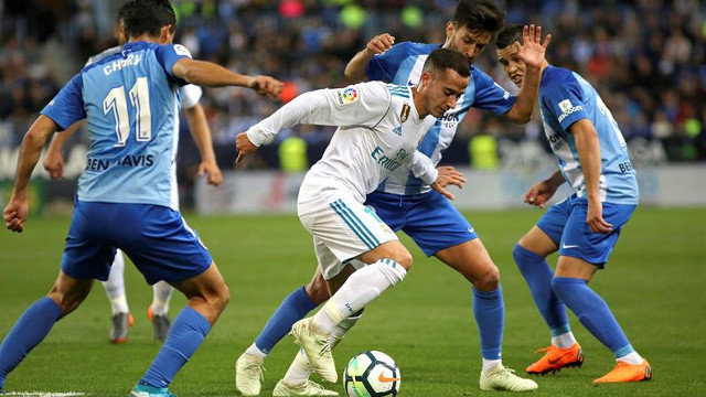 Lucas Vázquez intenta llevarse el balón ante los defensas del Málaga. DANIEL PÉREZ (EFE)