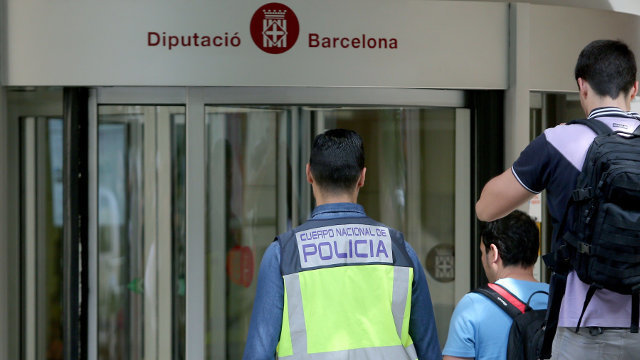 Varios policías se dirigen hacia la entrada de la sede de la Diputación de Barcelona.TONI ALBIR (Efe) 