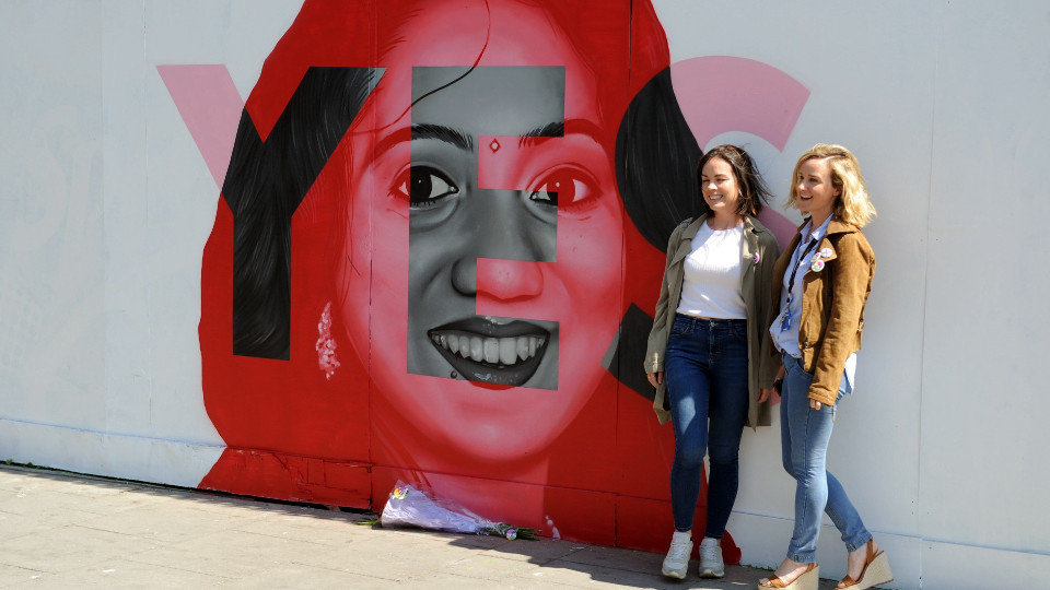 Dos mujeres junto a un mural de la campaña a favor del aborto en Dublín. AIDAN CRAWLEY (EFE)