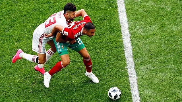 Ramin Rezaeian (izquierda) y Aziz Bouhaddouz, en un lance del partido. ETIENNE LAURENT (EFE)