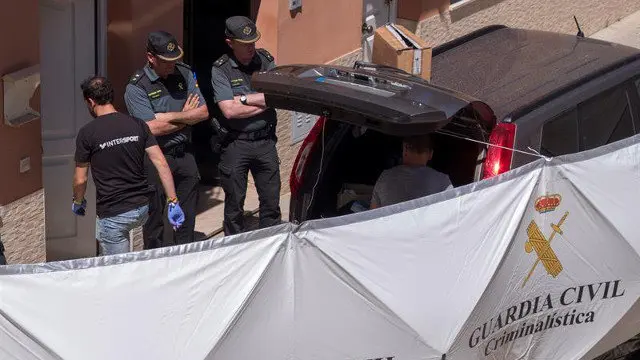 Agentes en la vivienda de Lepe en donde un hombre mató a una joven de 24 años. JULIÁN PÉREZ