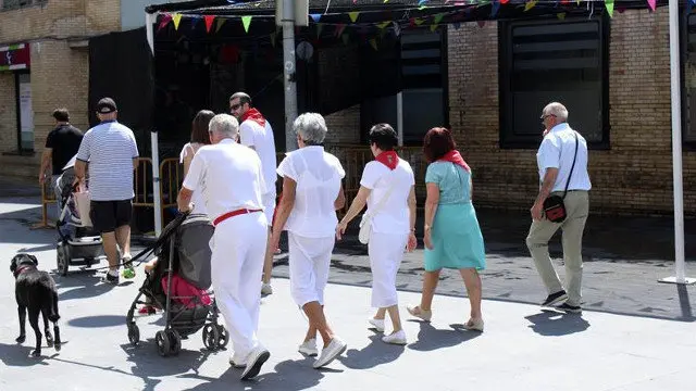 Un grupo de personas pasa por delante del bar de la localidad navarra de Tudela, donde tres jóvenes han sido detenidos por abusos sexuales a una menor. MIKEL ARILLA (EFE)