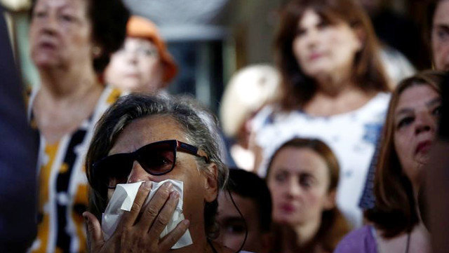 Fieles ortodoxos griegos asisten a un servicio conmemorativo por las víctimas del incendio forestal en una iglesia en Mati, Atenas. YANNIS KOLESIDIS (EFE)