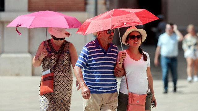 Unos turistas se protegen del sol con paraguas. KAI FÖRSTERLING (EFE)