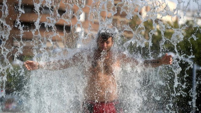 Un joven se refresca para combatir la ola de calor. EFE