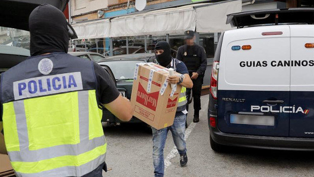 Agentes de Policía Nacional trasladan documentación incautada durante el registro de un local de hostelería en Boiro. LAVANDEIRA JR. (EFE) Detención Manuel Charlín