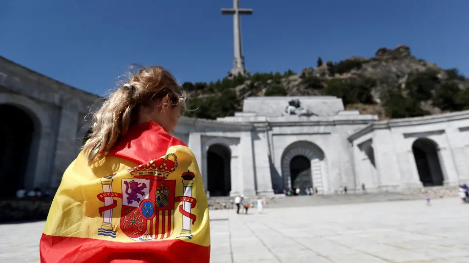 Una persona envuelta en una bandera en la explanada del Valle de los Caídos. MARISCAL (EFE)