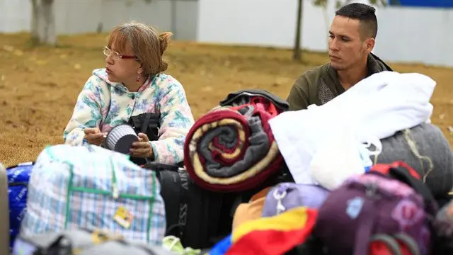 Venezolanos esperan para cruzar el paso fronterizo entre Ecuador y Perú. EFE