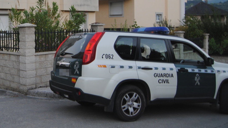 El coche de la Guardia Civil ante la casa que fue asaltada en Sarria. PORTO