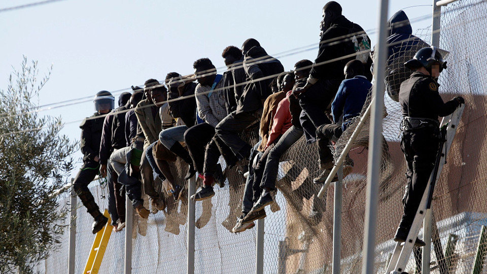 Un grupo de inmigrantes ante la valla de Melilla. ARCHIVO