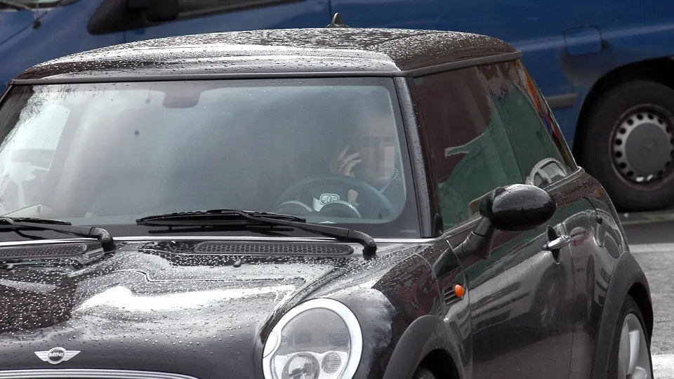 Un conductor habla por el móvil en el interior de un coche. AEP