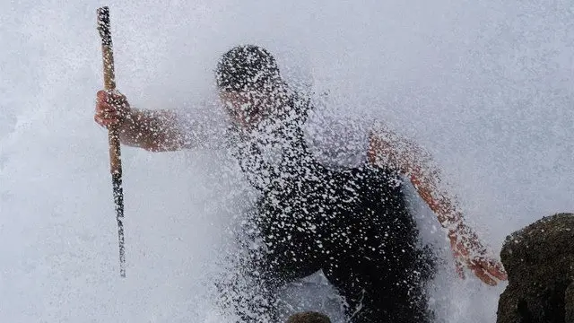 Un percebeiro escapa de la ola mientras faena los percebes en el cabo Roncudo, en Corme. LAVANDEIRA JR.