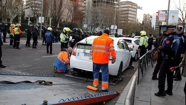 Una grúa se lleva uno de los taxis estacionados en la Castellana. EDUARDO OYANA