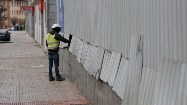 Un operario coloca chapas arrancadas polo vento na rúa Blanco Amor. GONZALO GARCÍA
