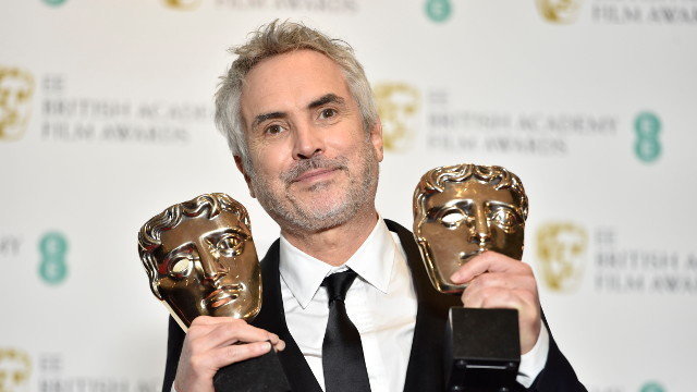 Alfonso Cuarón con dúas das máscaras que recibiu nos Bafta por &#39;Roma&#39;. NICK ACHEN (EFE)