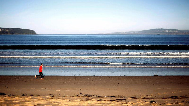 Buen tiempo - Una persoa hace deporte en la playa Grande de Miño este lunes. CABALAR (EFE)