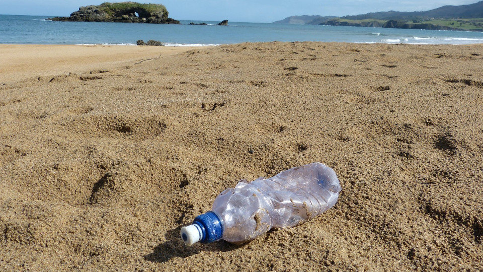Unha botella de plástico nunha praia. EP