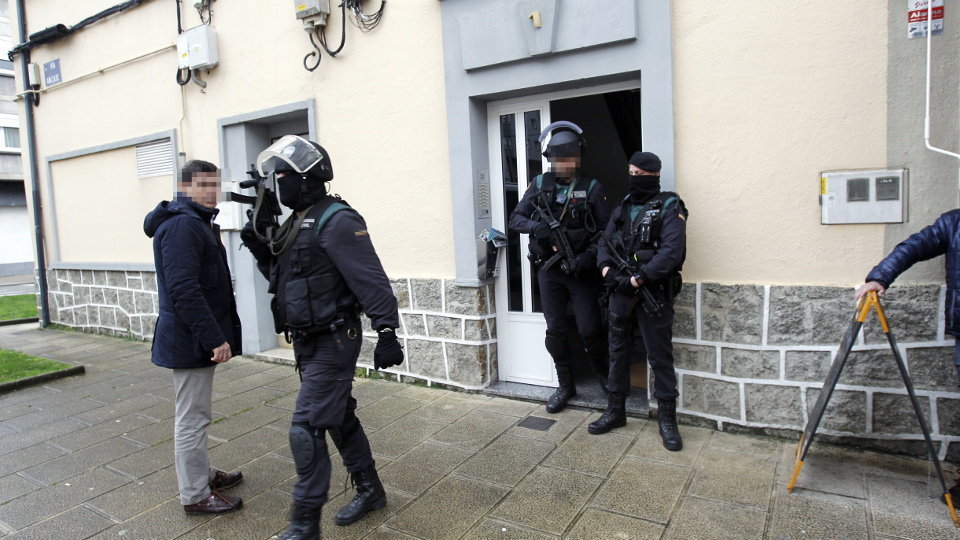 Agentes fuertemente armados salen de una de las casas sindicales, en Lugo. XESÚS PONTE