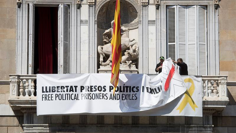 Momento en el que dos operarios retiraban las pancartas del Palau de la Generalitat. MARTA PÉREZ, EFE