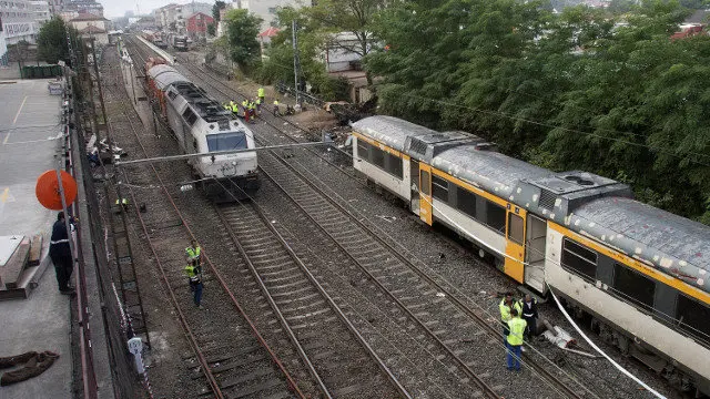 Varios operarios junto al tren que descarriló en O Porriño. ARCHIVO