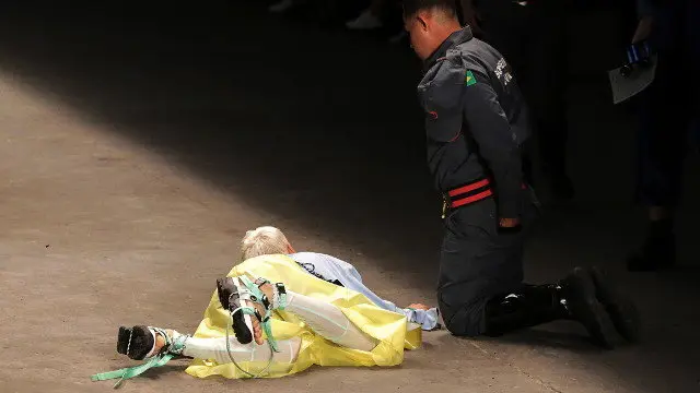 Un bombero auxilia a Tales Cotta después de que el modelo cayese en la pasarela. EFE