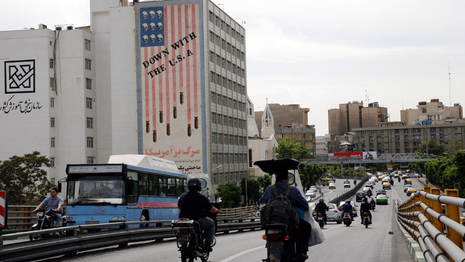 Conductores circulan junto a un edificio en el que aparece una pintada antiamericana en Teherán.ABEDIN TAHERKENAREH (Efe)