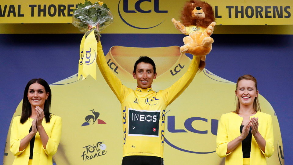 Egan Bernal celebra en el podio su victoria virtual en el Tour de Francia 2019. GUILLAUME HORCAJUELO (EFE)