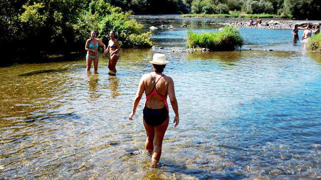Bañistas en las termas de O Muiño da Veiga y la zona fluvial del río Miño. BRAIS LORENZO (EFE)