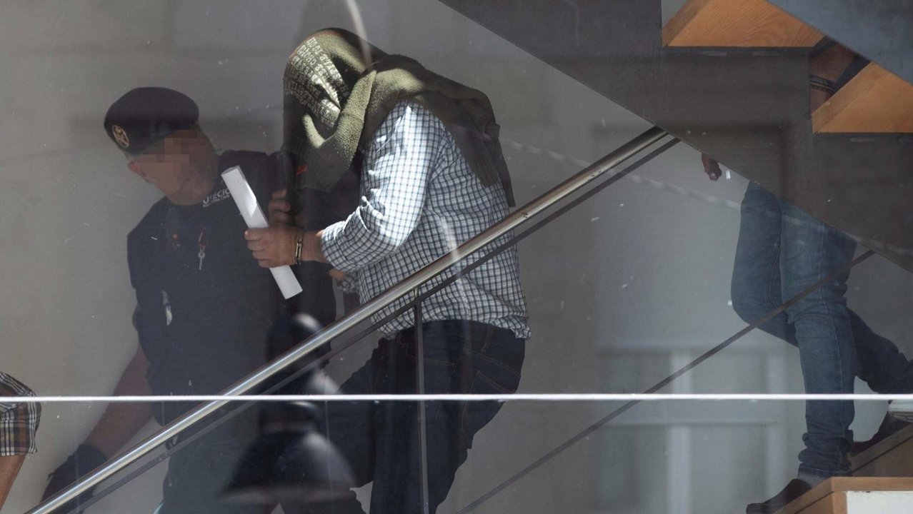 José Luis Abet sale de los juzgados con la cabeza cubierta por un jersey. AEP