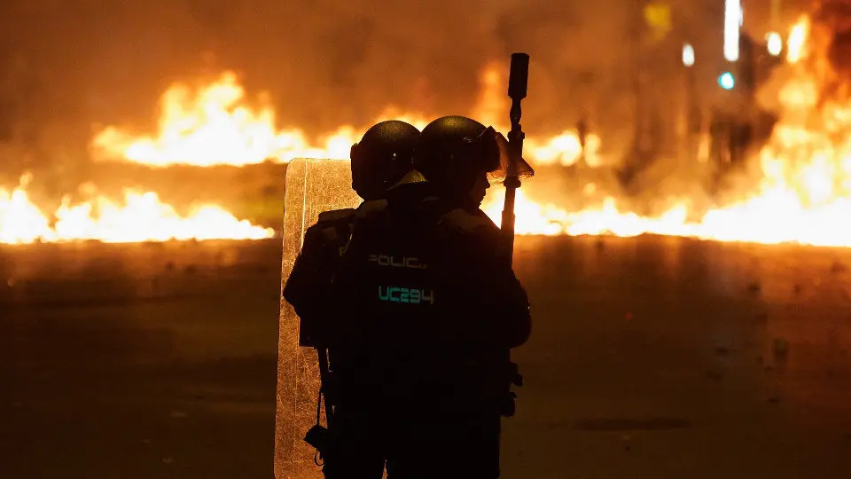 Agentes antidisturbios se enfrentan a los manifestantes durante los altercados en Barcelona de este miércoles. DAVID BORRAT (EFE)