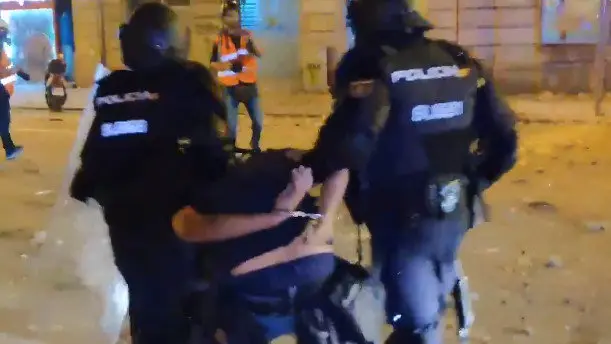 Momento en el que los agentes se llevan al fotógrafo de El País. TWITTER (@GPisarello)