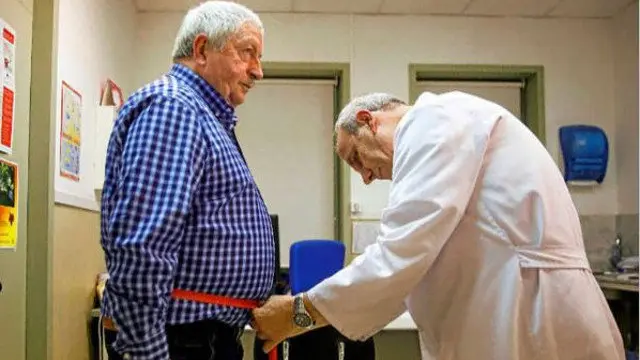 Un médico toma medidas a un paciente con sobrepeso. EL MUNDO